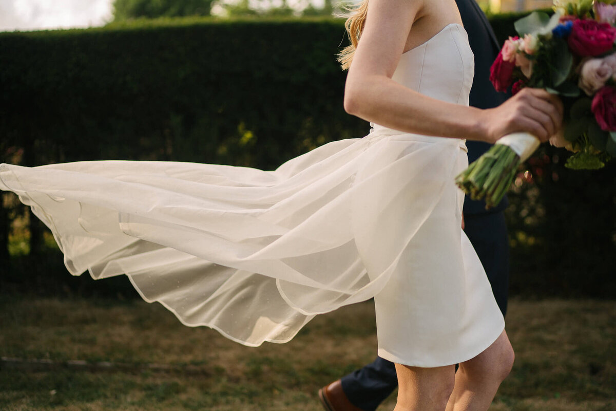 A brides dress flowing in the wind.