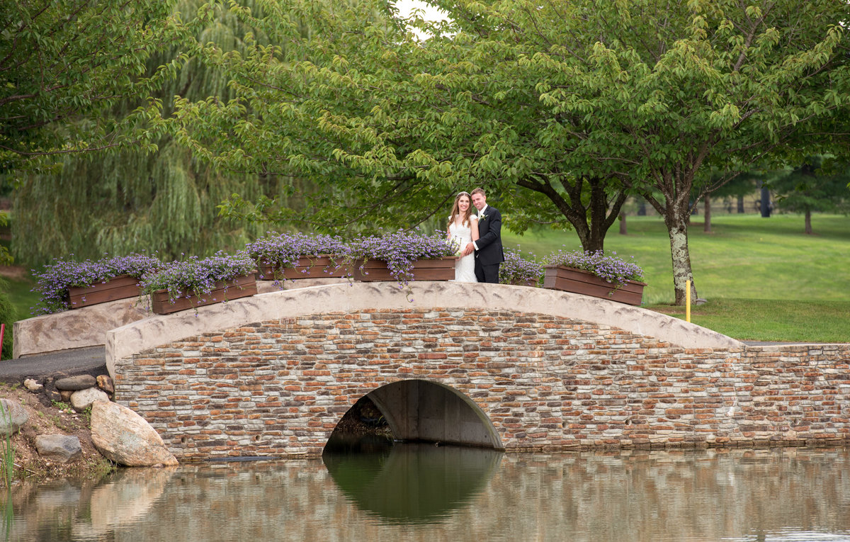 bride and groom standing on bridge at Willow Creek Golf and Country Club