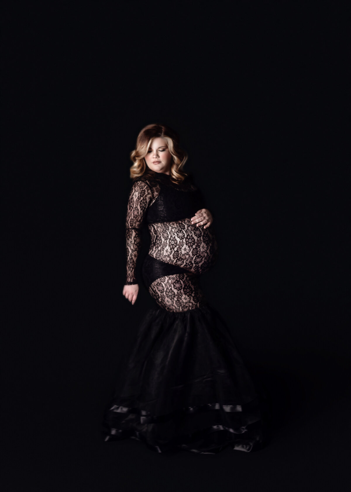 Women wearing black maternity gown with glam makeup during maternity photoshoot in Franklin Tennessee photography studio