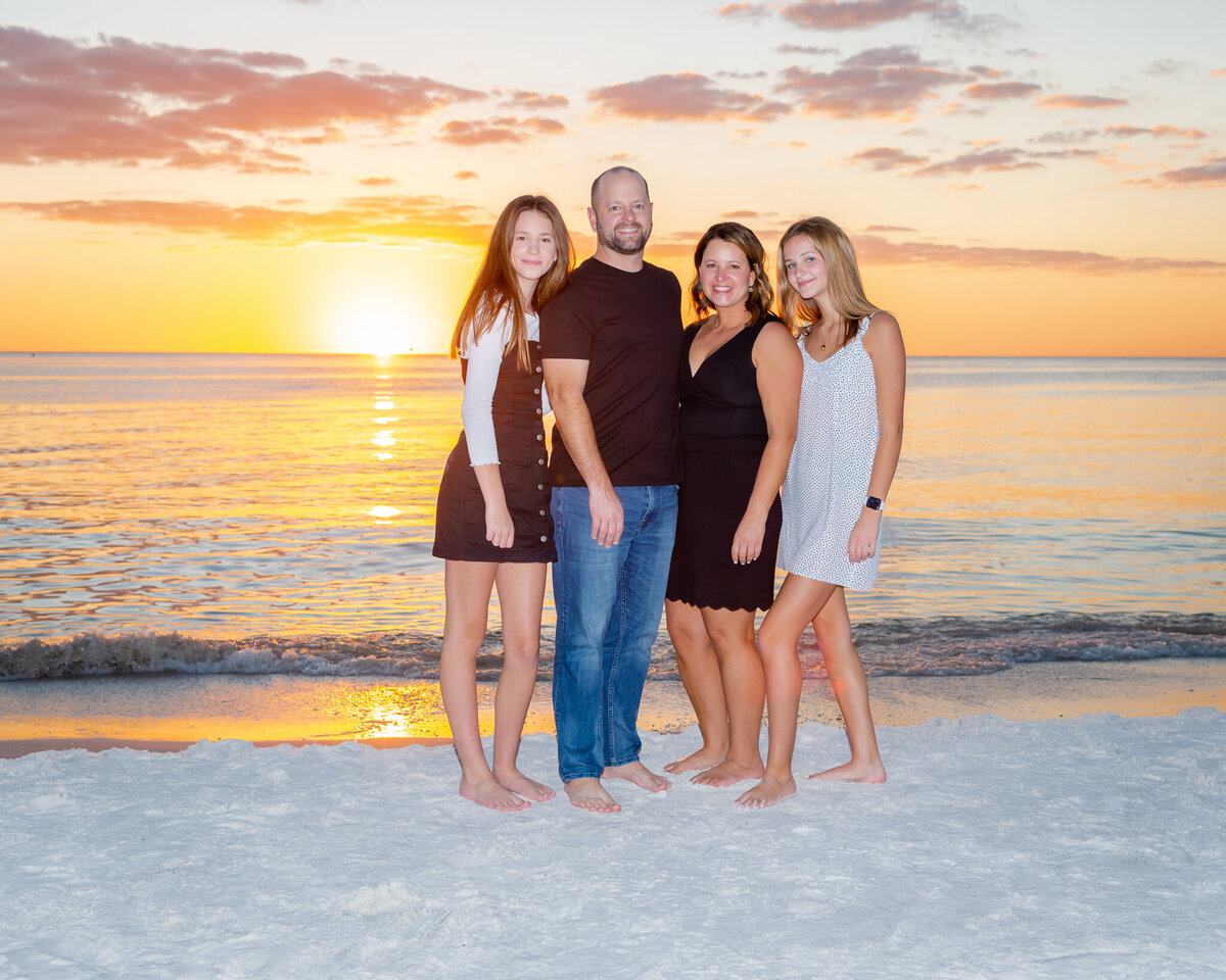 Family poses for a sunset beach photo