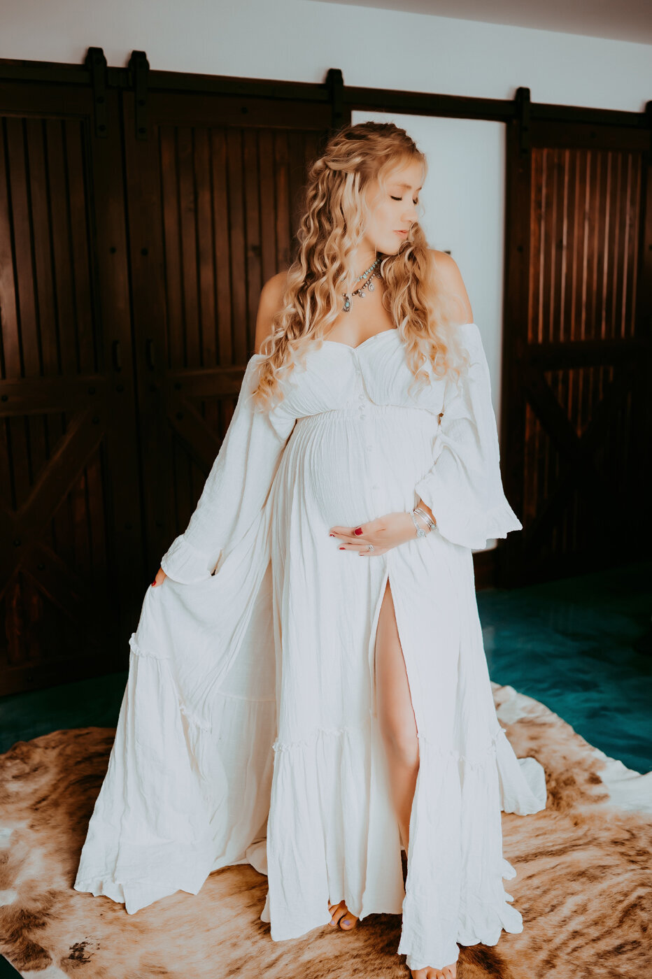 Maternity mama posing indoors in a white gown