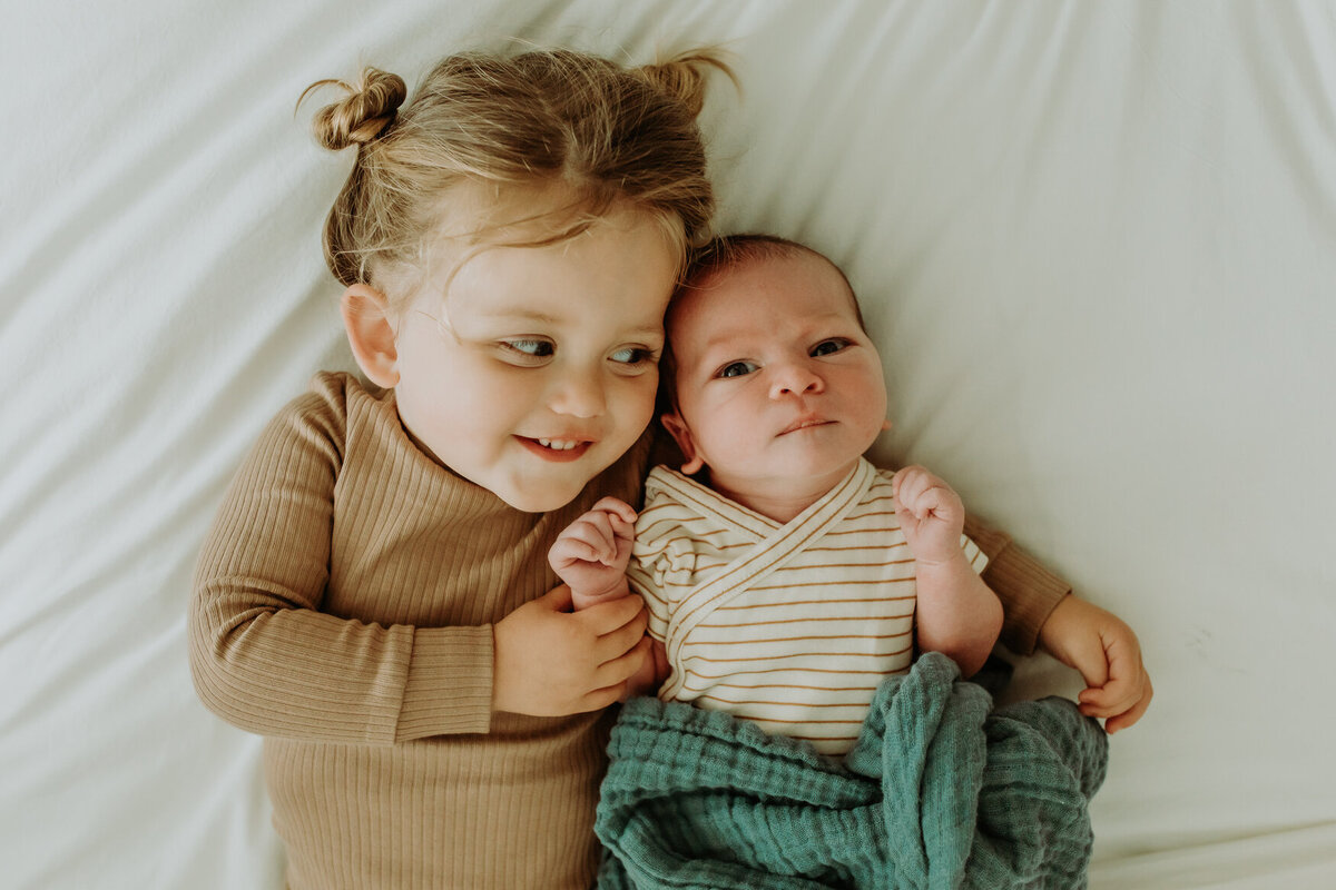 Sibling with newborn snuggling