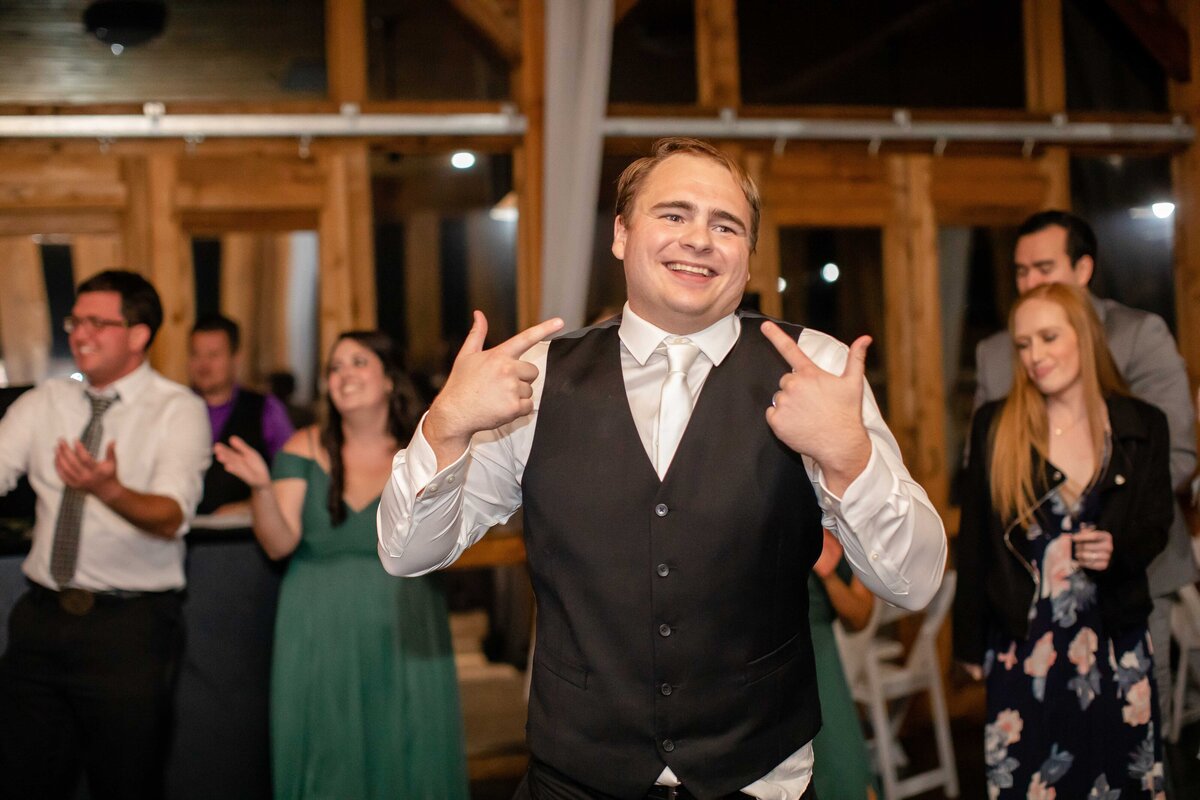 groom smiles and points to his face at New Braunfels Texas wedding