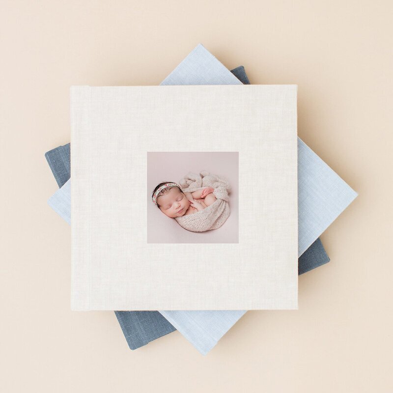 Stack of newborn photo albums by nj portrait photographer