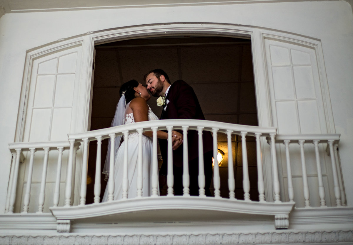 Bride and groom about to kiss on balcony at George Washington Hotel
