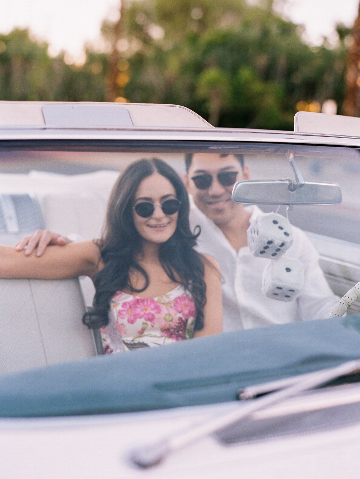couple sitting in vintage car with sunglasses