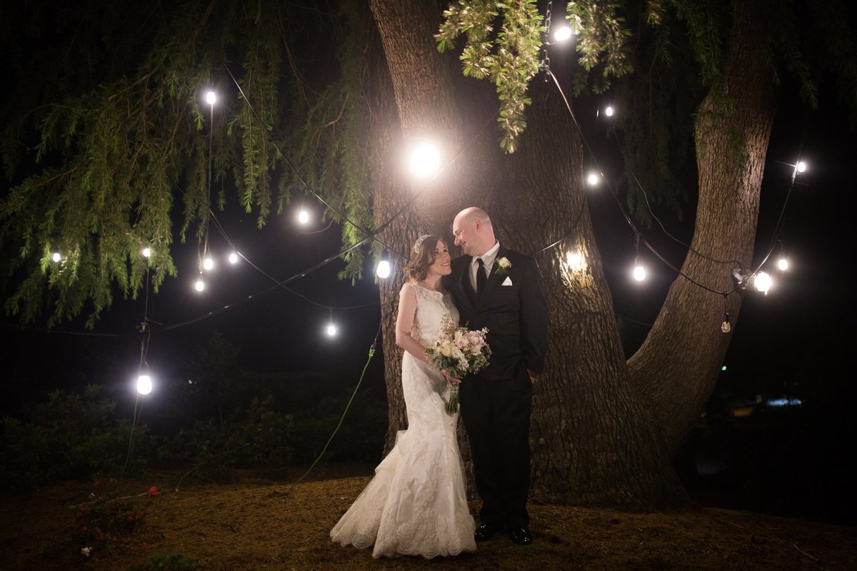 Wedding Photographer, couple standing together under lights at night