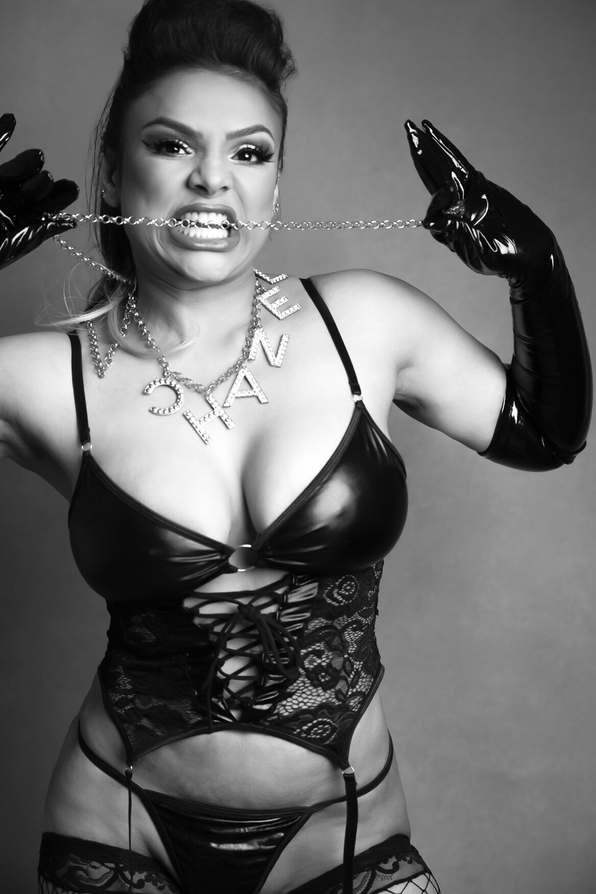 women wearing black lingerie and latex gloves biting a  chain