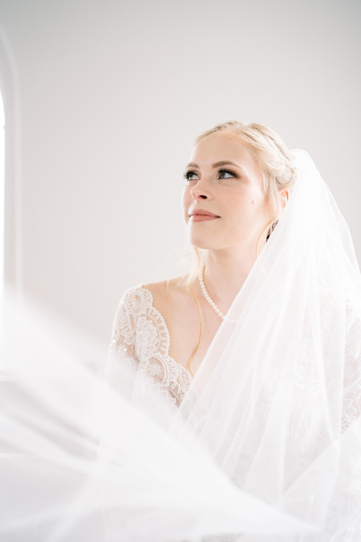 bride looks to the side, veil is draped in front of her and across the screen