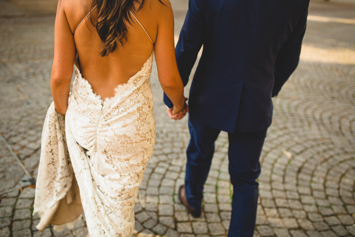 bride and groom holding hands on cobbles