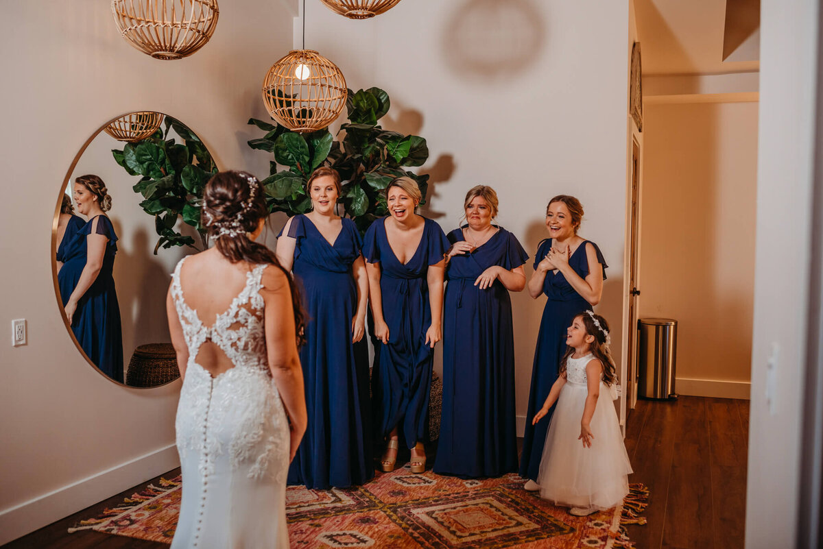photo of bridesmaids shocked reaction as they see the bride for the first time