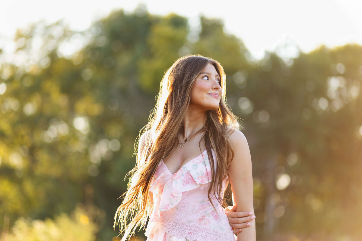 girl looking over her shoulder at sunset