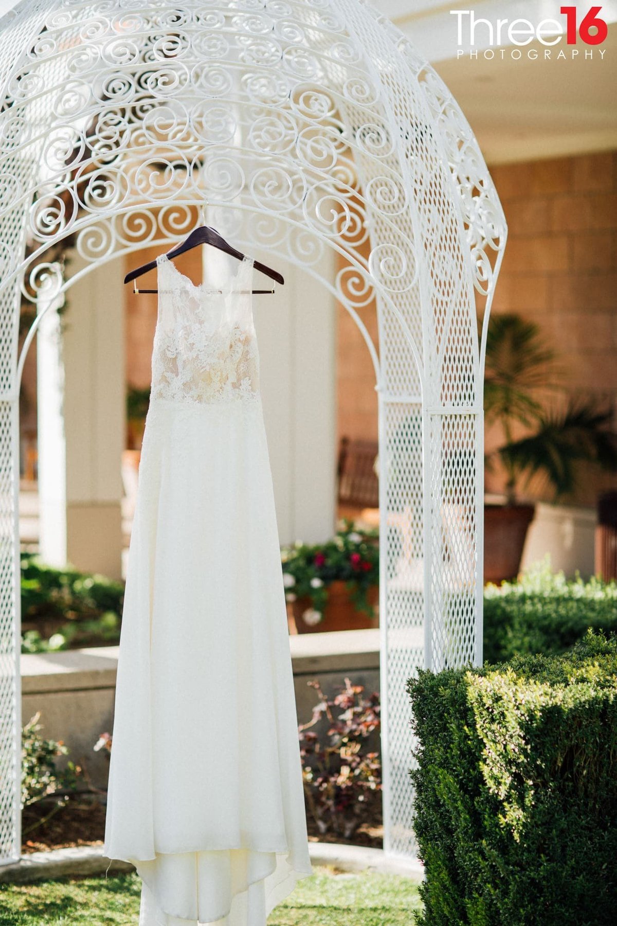 Bride's dress hangs from a small gazebo