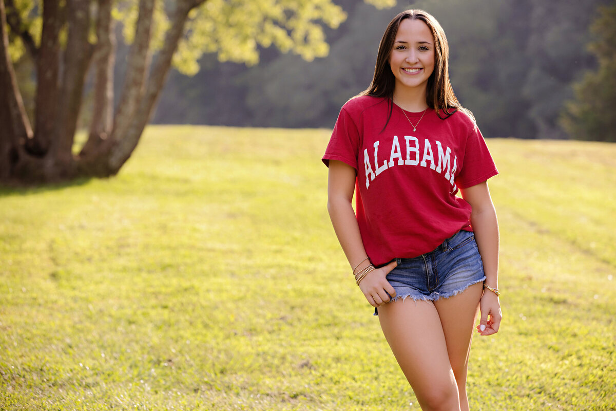 Photo of a HS Senior wearing a red Alabama t-shirt during her portrait session for her graduation announcements. Photos taken at Anne Springs Close Greenway in Fort Mill, SC.