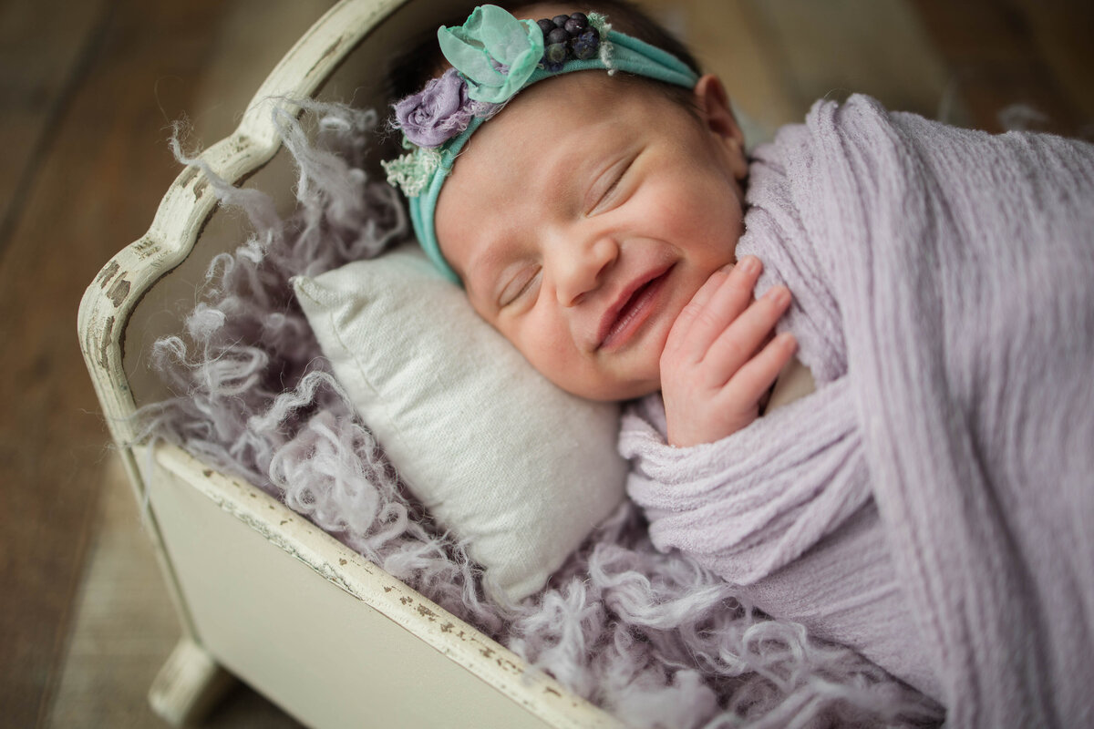 Newborn Baby Girl Wrapped in Purple