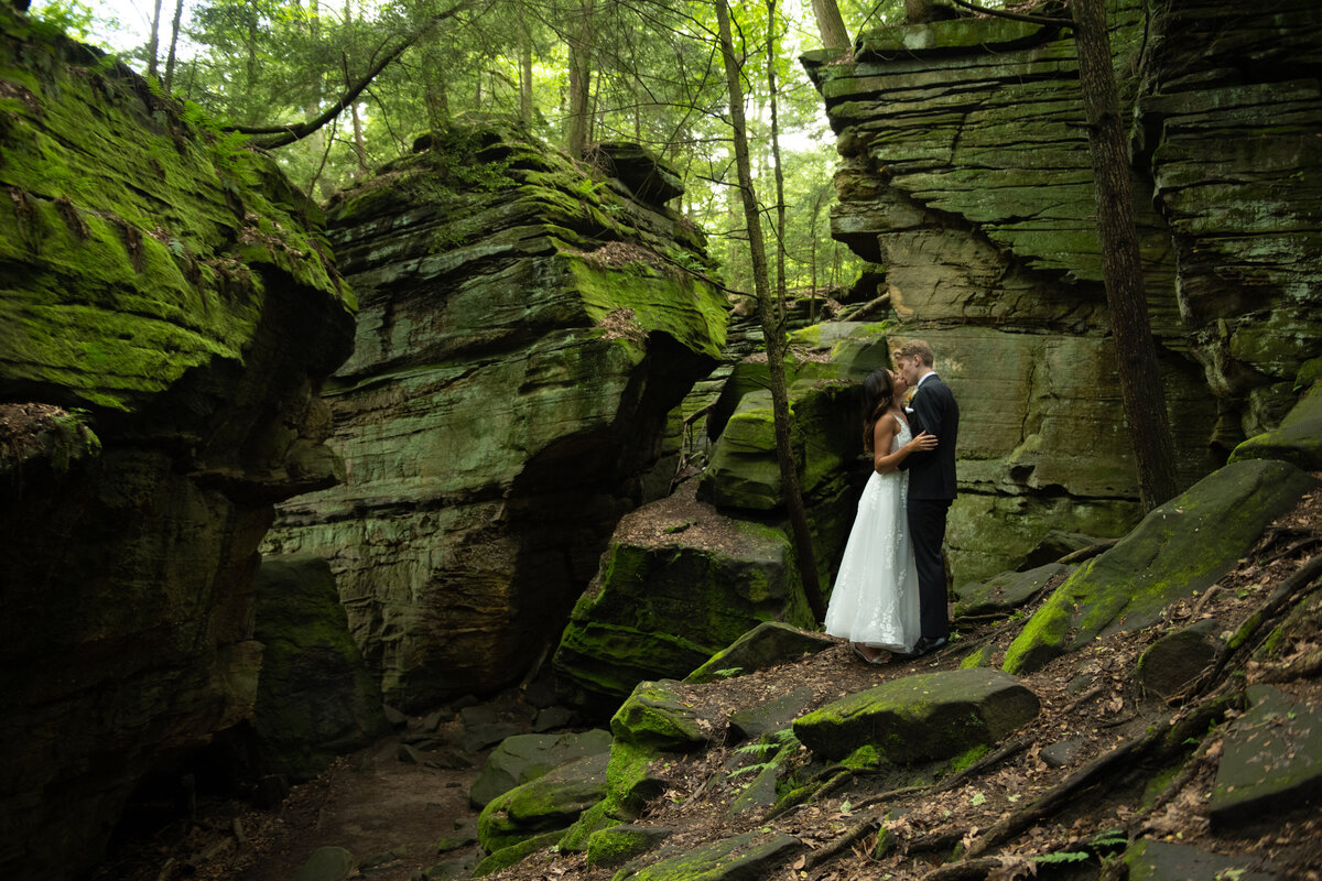 Ohio bride and groom in a white dress and black tux, kissing in Cuyahoga Valley National Park on their wedding day. Photo taken by Columbus wedding photographer Aaron Aldhizer