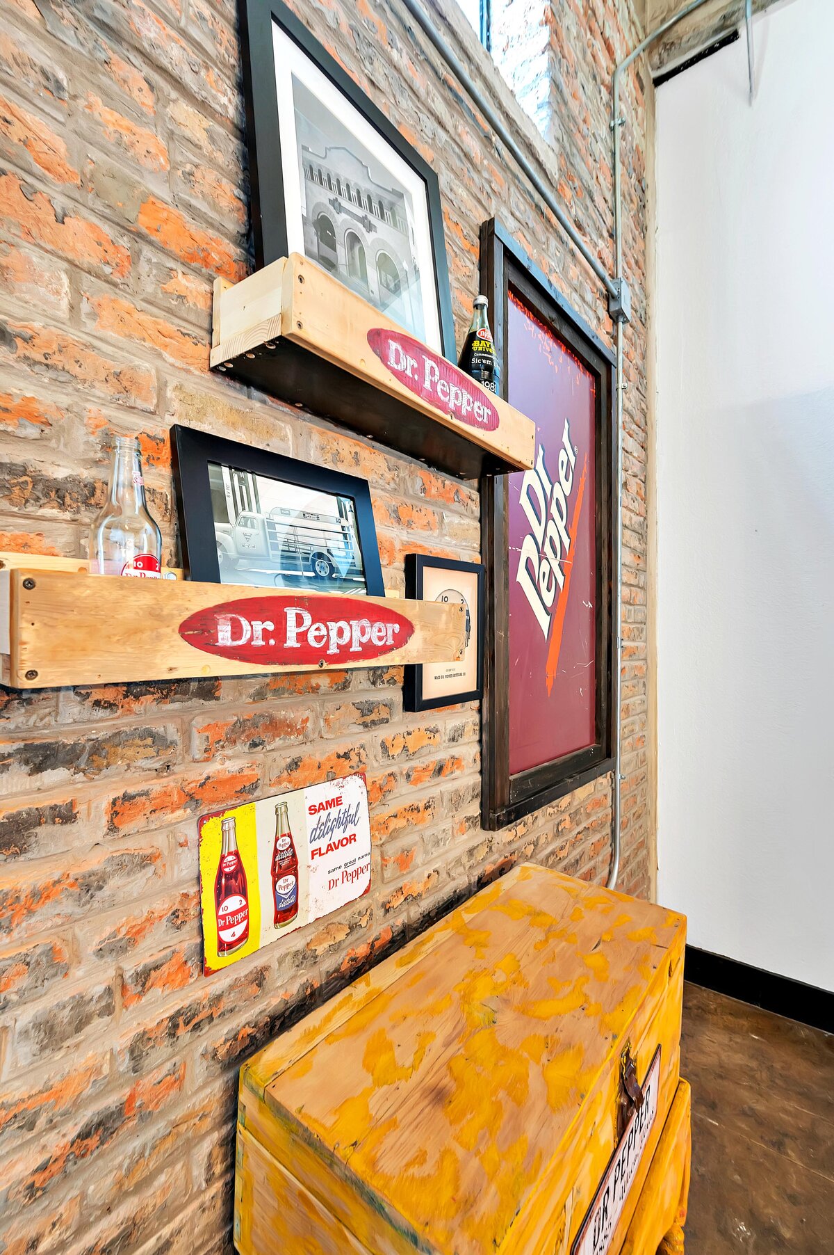 This is a wall displaying the history of Dr. Pepper in the living room of this one-bedroom, one-bathroom vintage industrial condo with Smart TV, free Wi-Fi, and washer/dryer located in downtown Waco, TX.