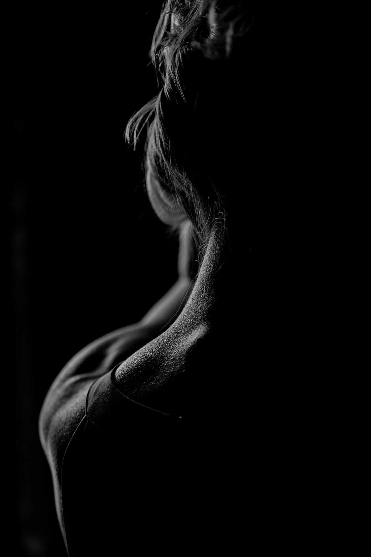 En sensuell nakken med lys og skygger på boudoirfotografering i Oslo.
