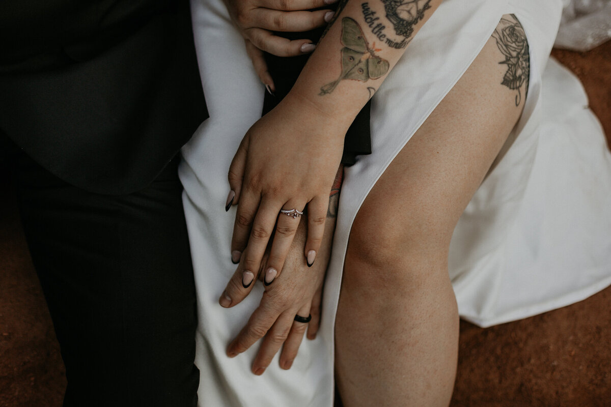 close up of bride and grooms hands in their laps