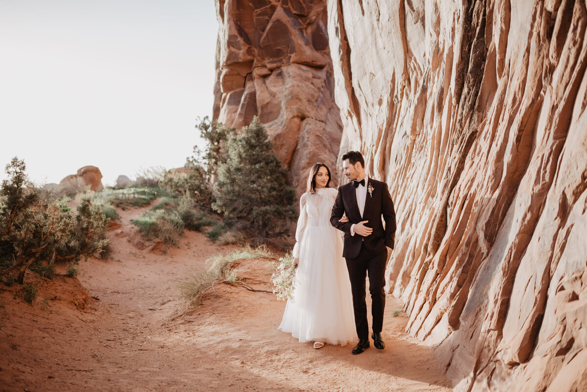 Utah elopement photographer captures bride holding groom's arm during portraits