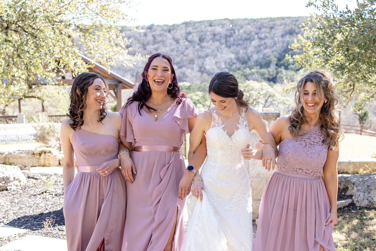 bride walks candidly with 3 bridesmaids in pink in Boerne Texas