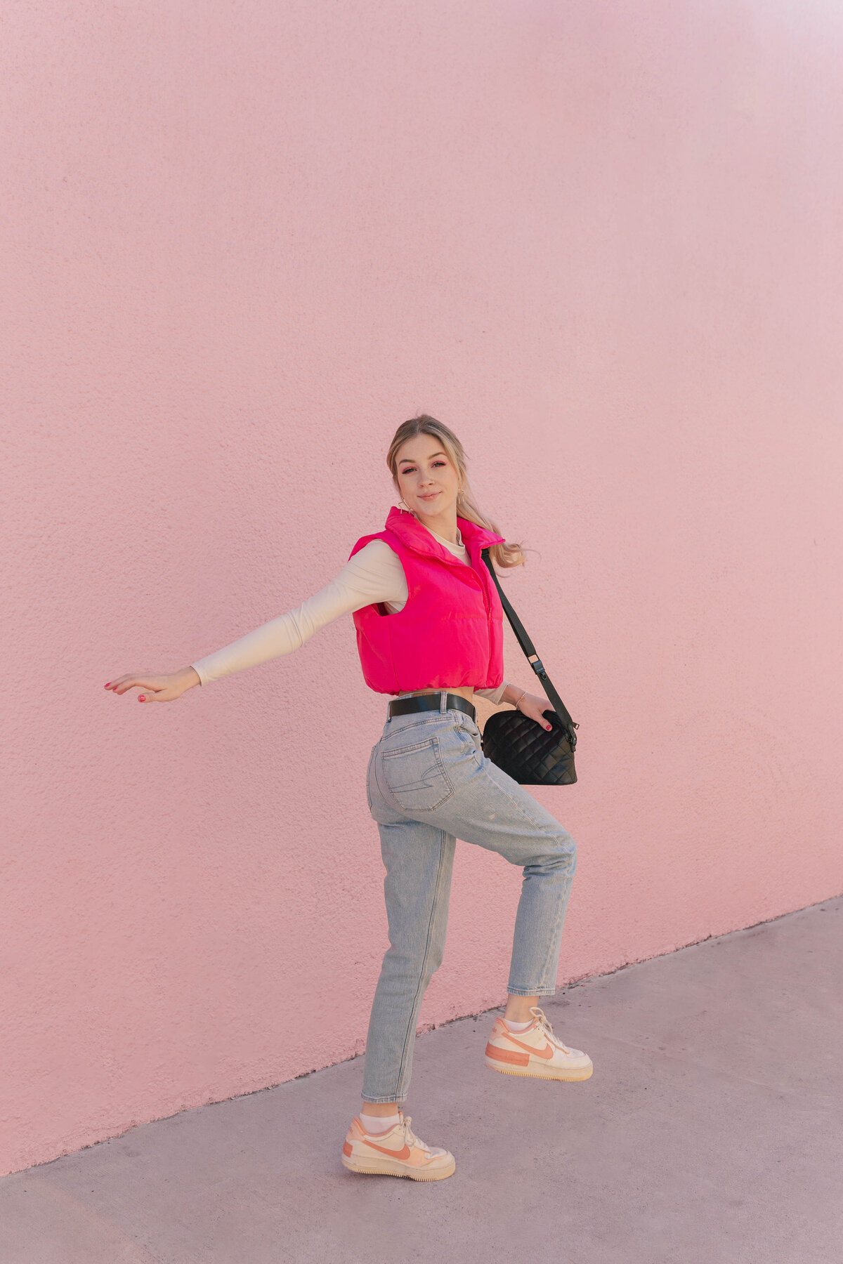 Sporty barbie strikes a pose in front of a pink wall in Houston