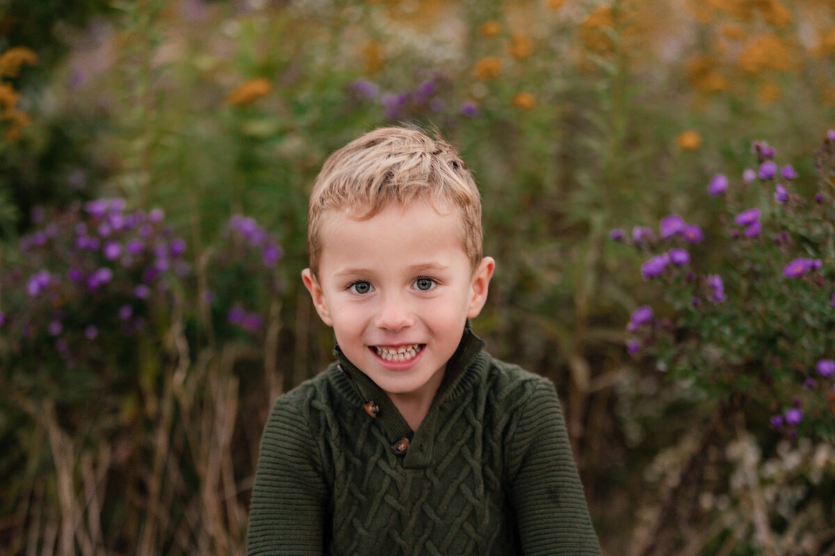 An adorable boy smiles for the camera during a portrait.
