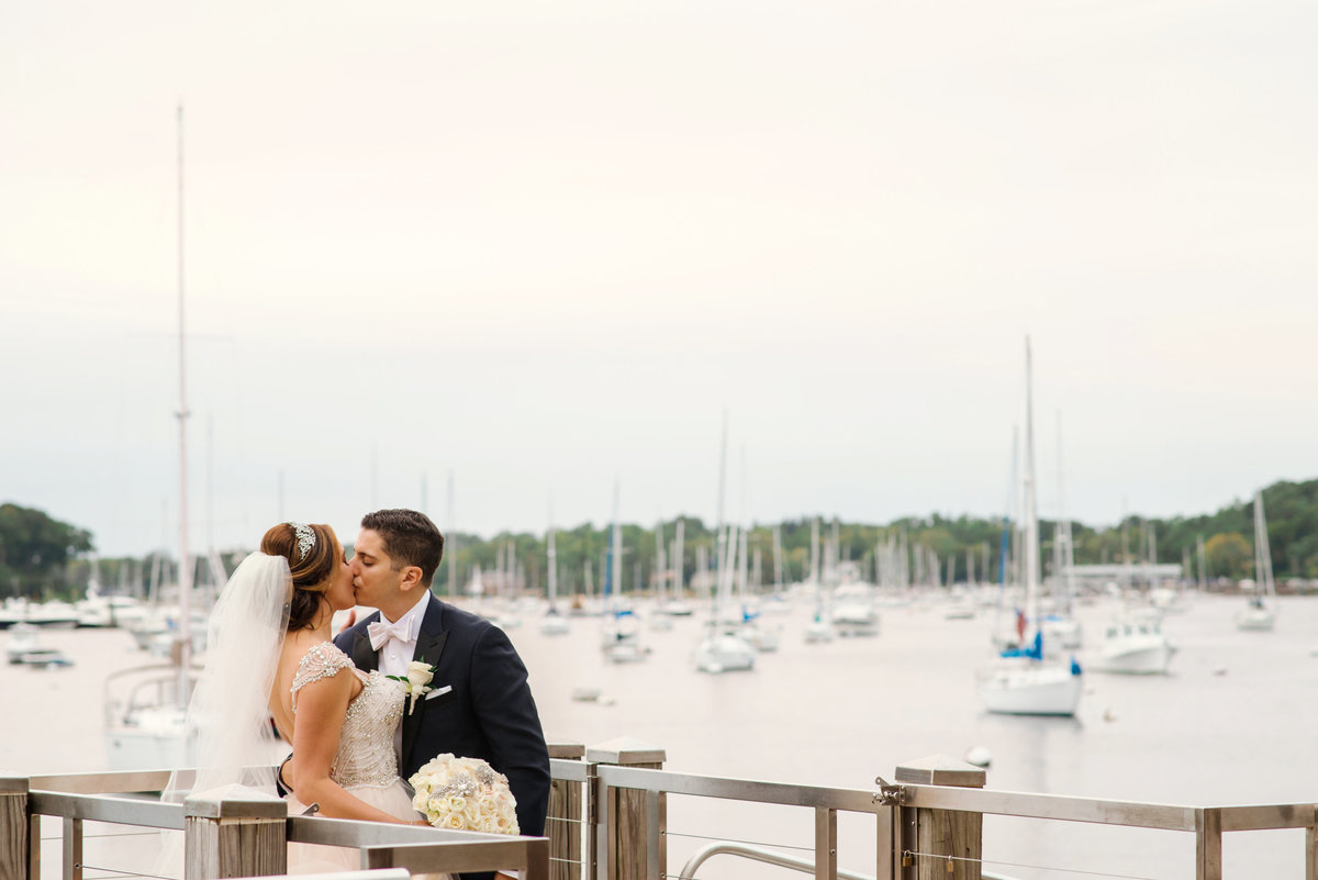 Bride and Groom kissing at the Dock of Harbor Club