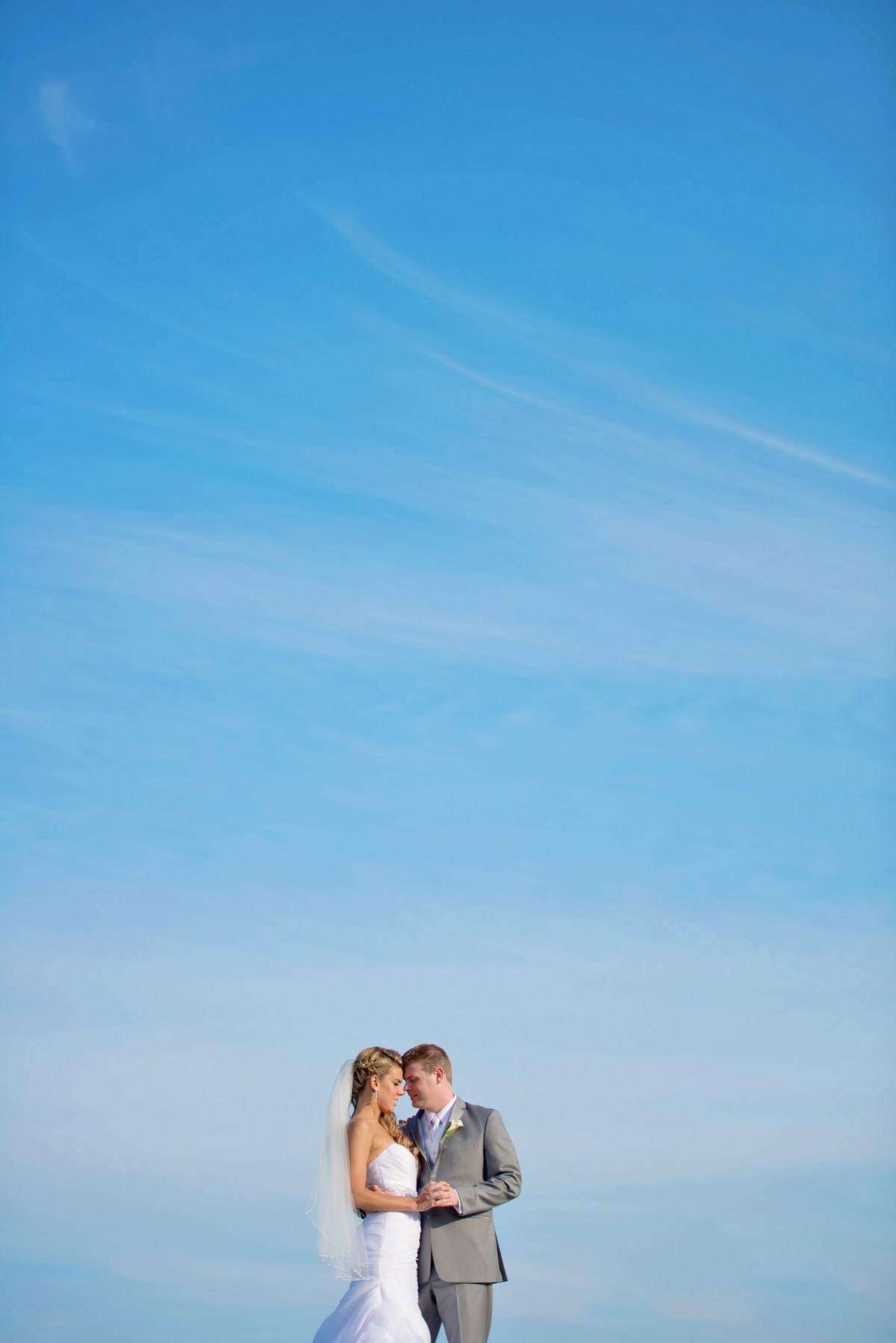 Bride and groom photo with blue skies at Oceanbleu