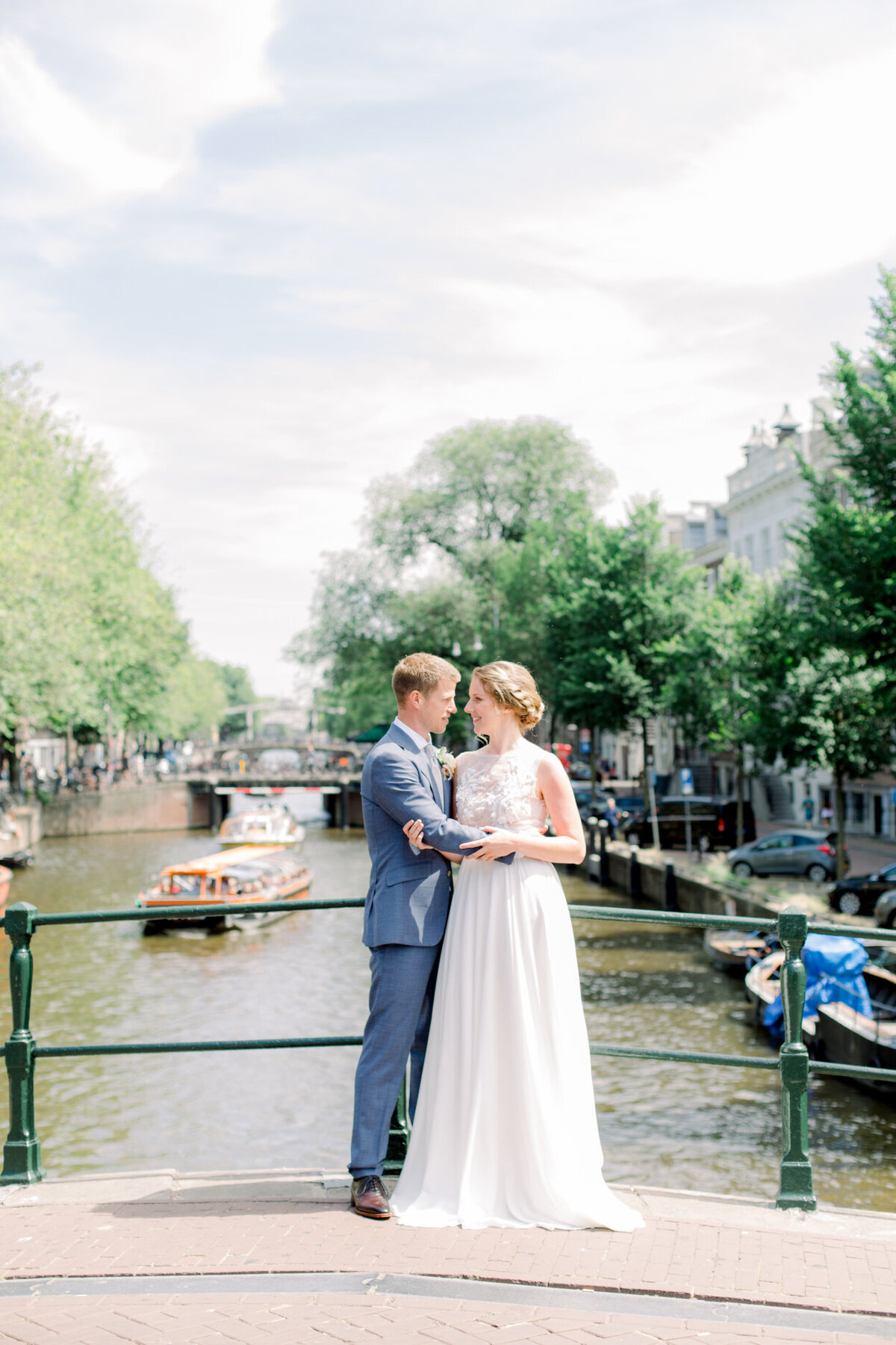Wedding portrait of the bride and groom in Amsterdam overlooking the gracht for a photoshoot organized by Lovely & Planned