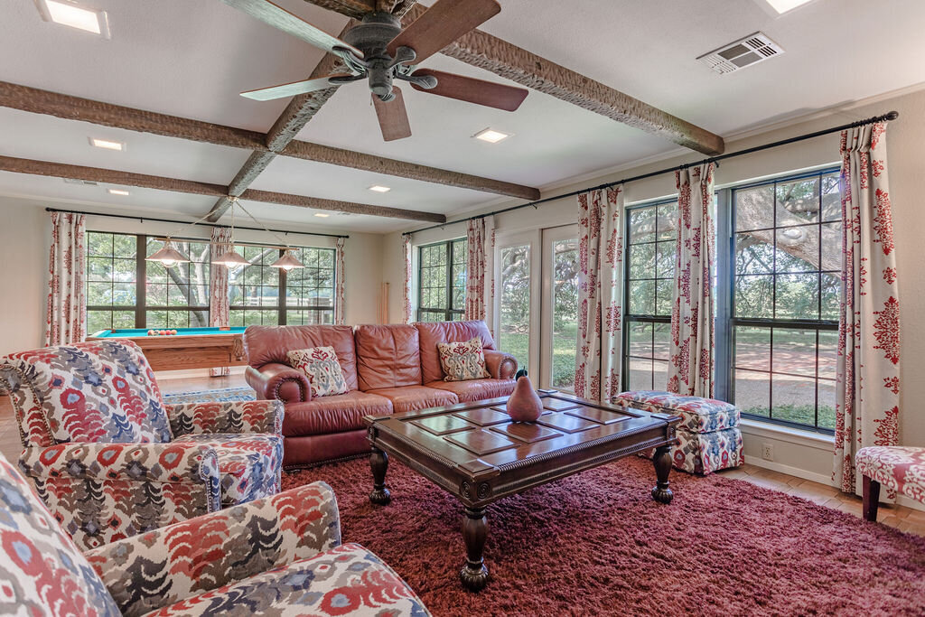 Cozy living room with smart TV and plenty of comfortable seating in this 5-bedroom, 4-bathroom vacation rental house for 16+ guests with pool, free wifi, guesthouse and game room just 20 minutes away from downtown Waco, TX.