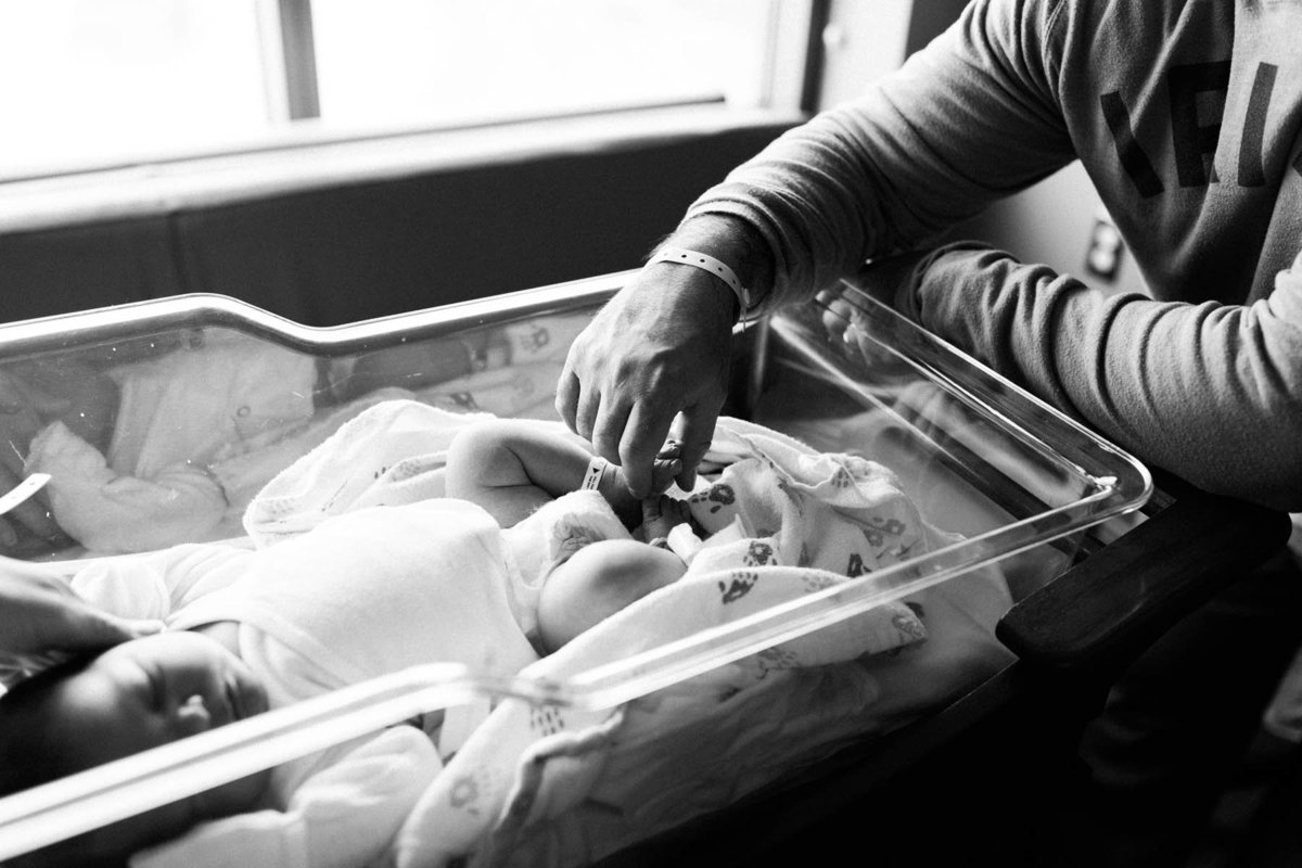 Elle Baker Photography captures father touching newborn baby's toes at hospital