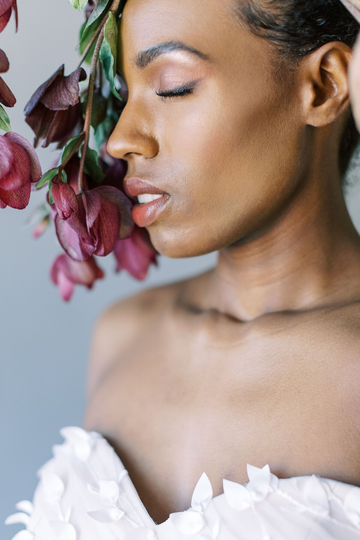 African American Bride closes eyes with hellebores