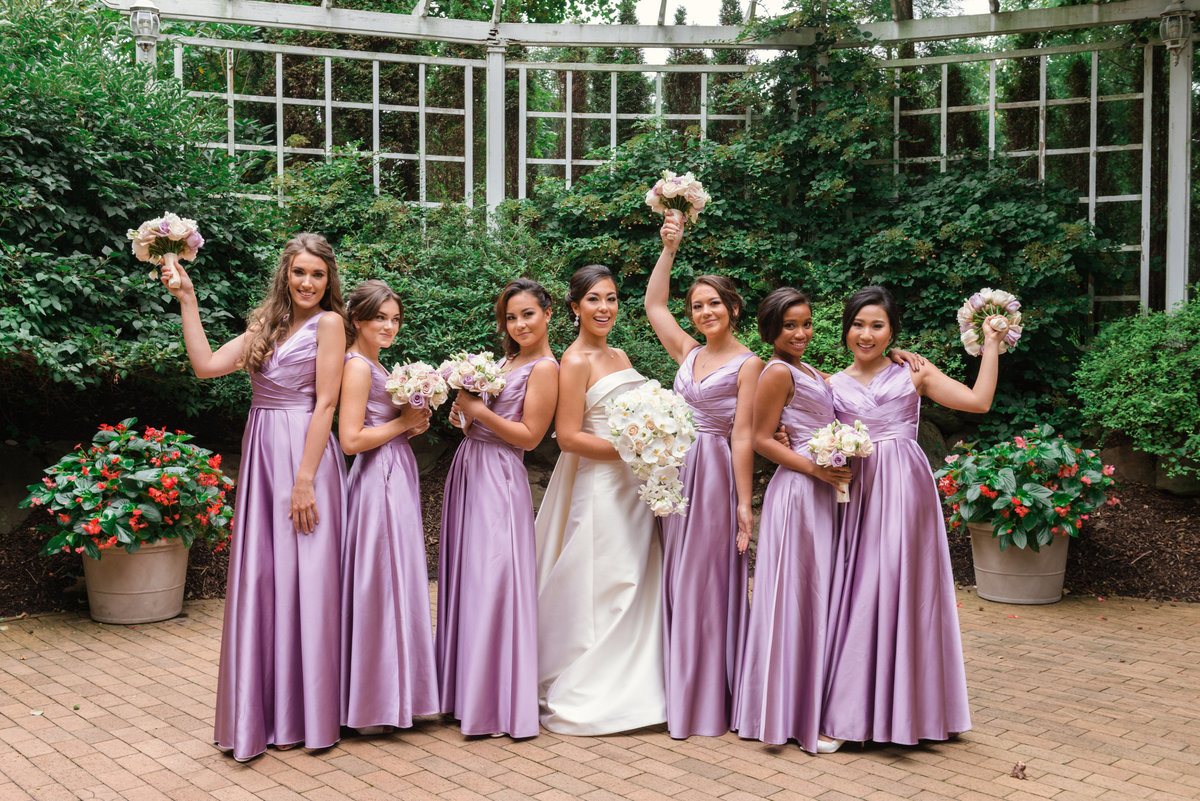 photo of bridesmaids with bride in the outdoor garden area from wedding reception at The Garden City Hotel