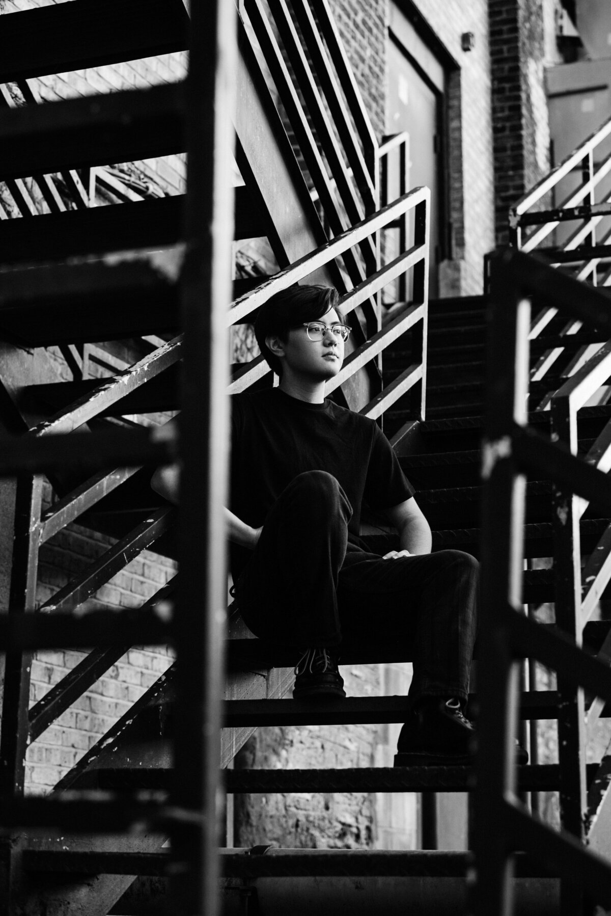 high school senior photo of boy on stairs in black and white