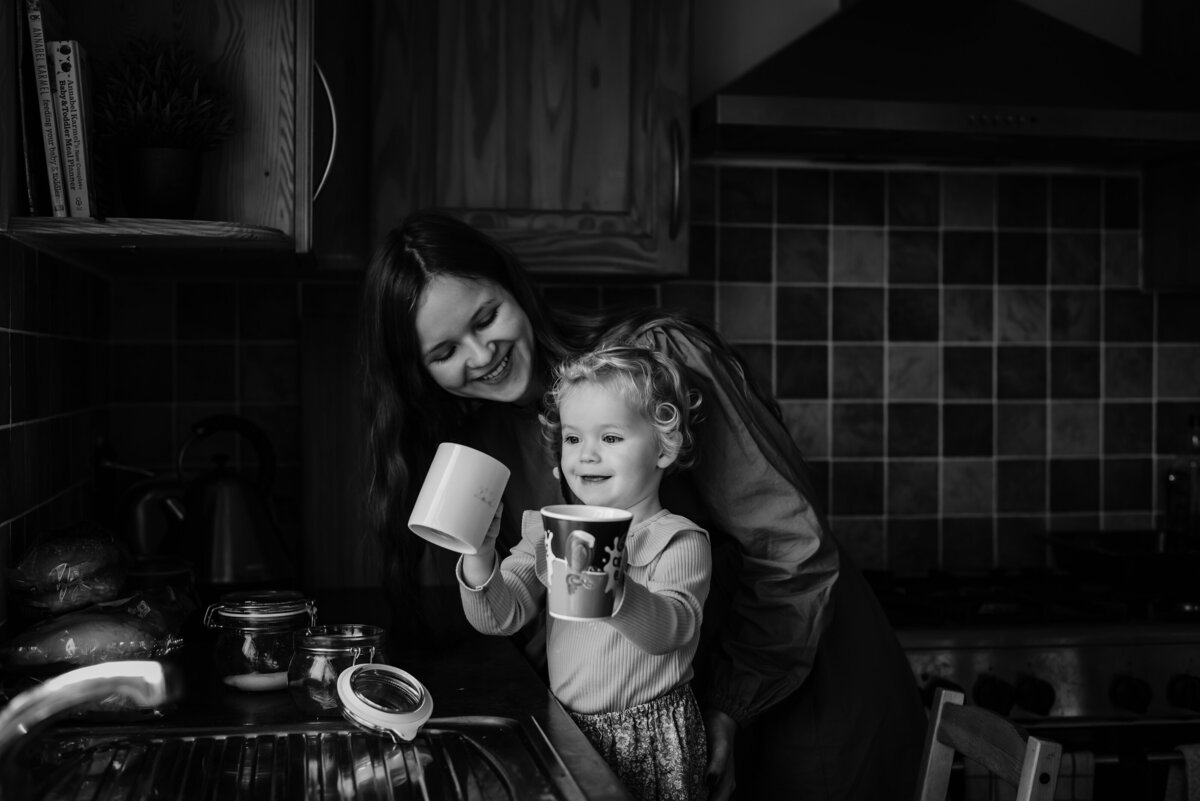 Little girl helping he rmum make a cup of tea during family photoshoot