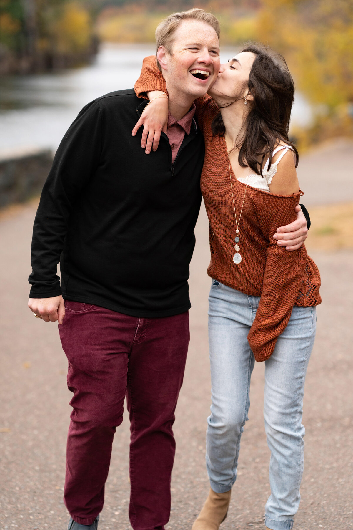 Woman kisses man while walking in Taylor's Falls, Minnesota.