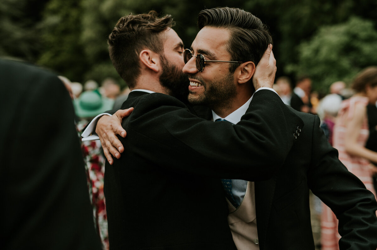 two men embracing at wedding reception