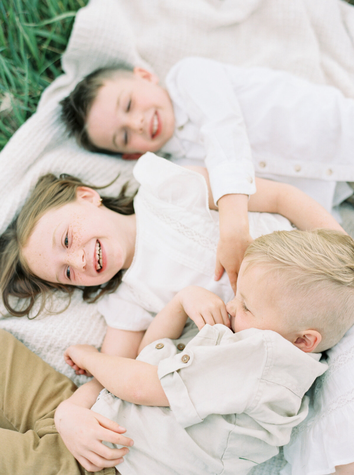 Three children on a blanket photographed by Chelsea Sliwa Photography