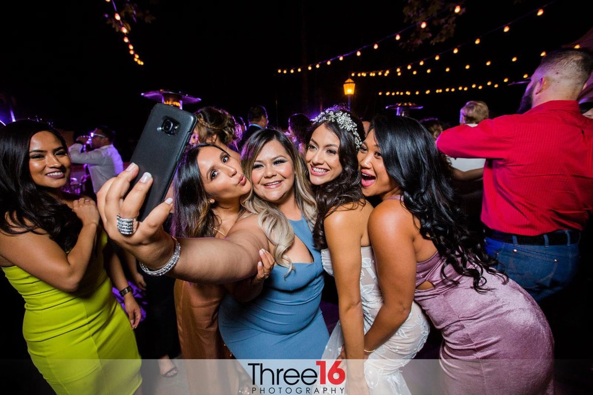Ladies squeeze in for a selfie with the bride on the dance floor