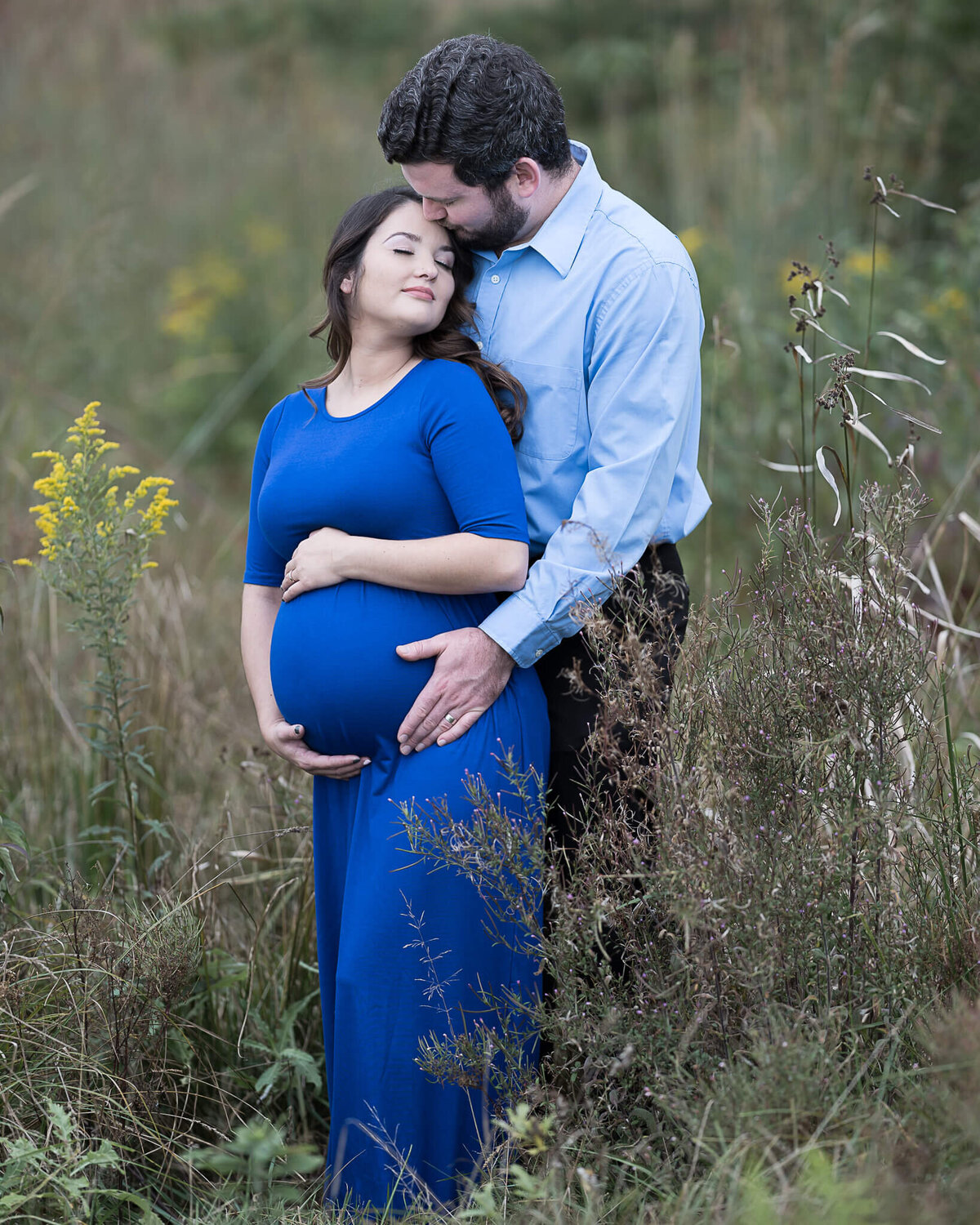Beautiful maternity couple pose at beautiful outdoor location.