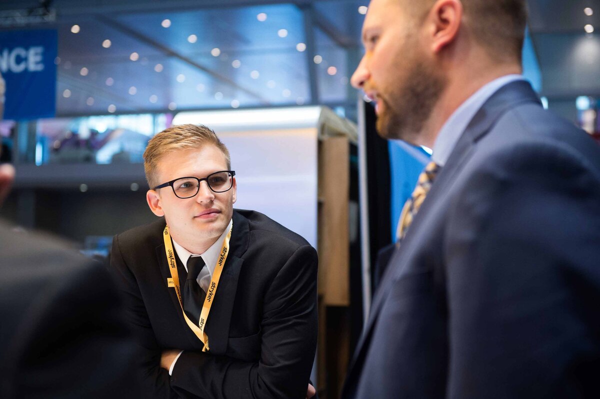 Sales Rep looks on interestingly as he listens at Stryker booth in Boston