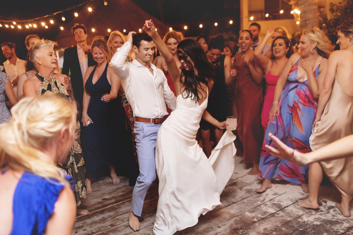 Bride and groom dancing at wedding with guests watching