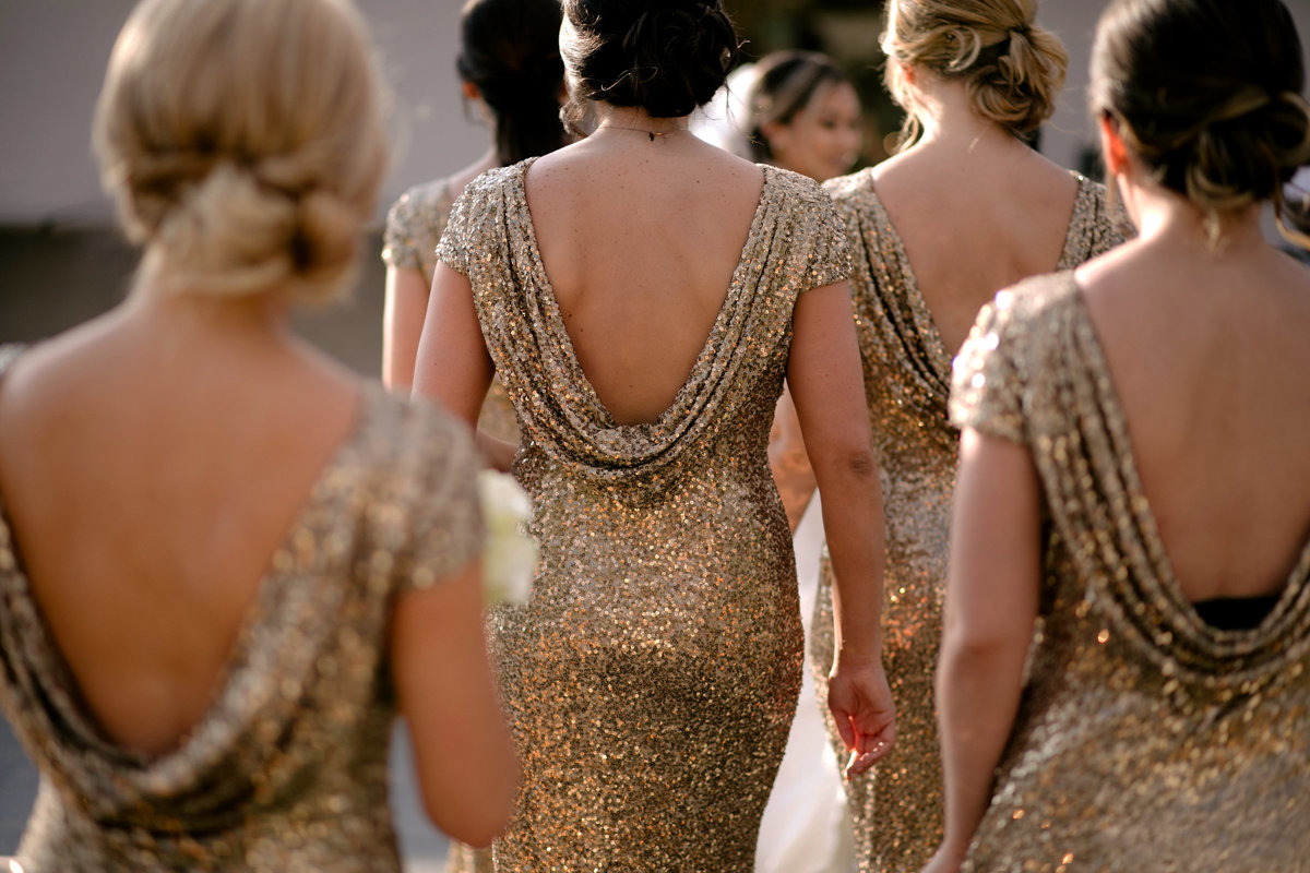 Bridesmaids dressed in gold sequins, walking toward bride