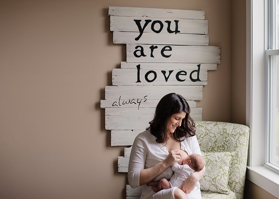 nursing mother and newborn in a chair with a sign that reads you are loved always