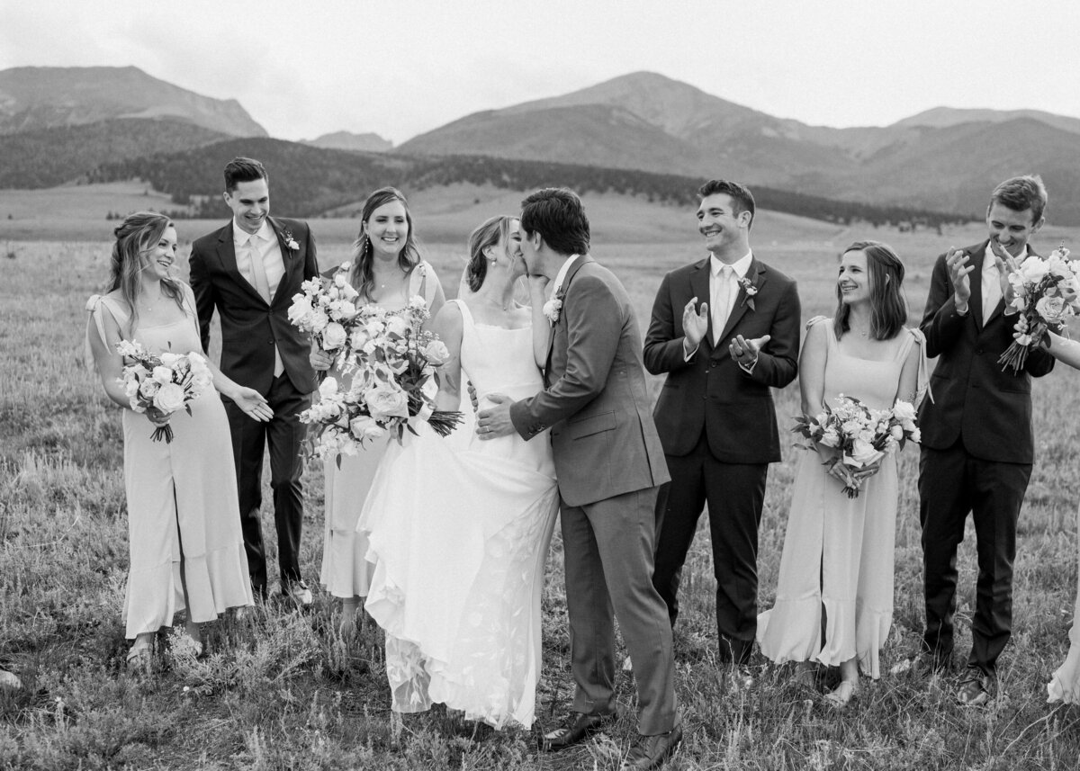 A fun black and white image of a happy bridal party and newly married couple