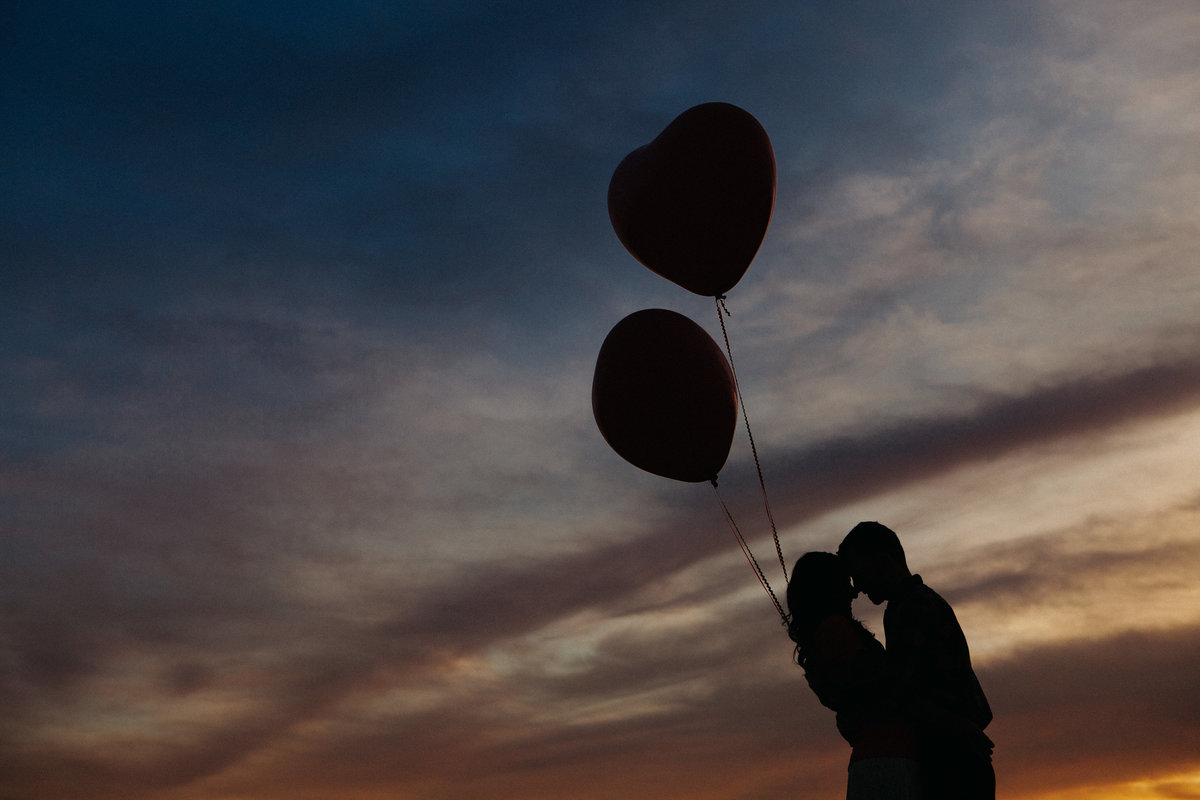 silhouette with balloons engagement photo