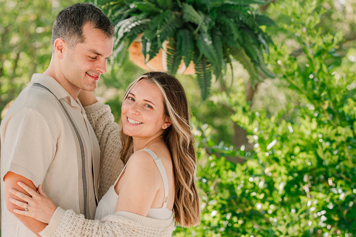 An engaged couple embracing and smiling on a historic estate venue in Raleigh enjoying their Raleigh wedding photos by JoLynn Photography