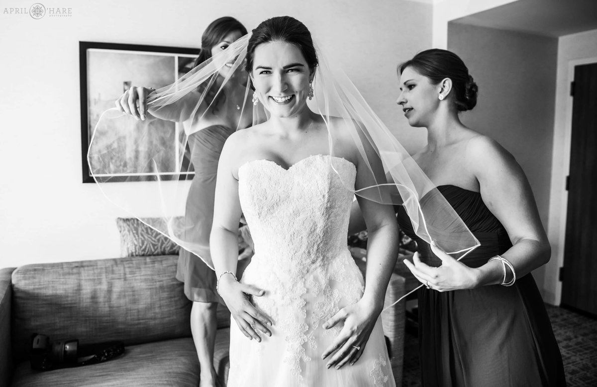 A B&W Colorado Wedding Photo of a bride getting help with her veil