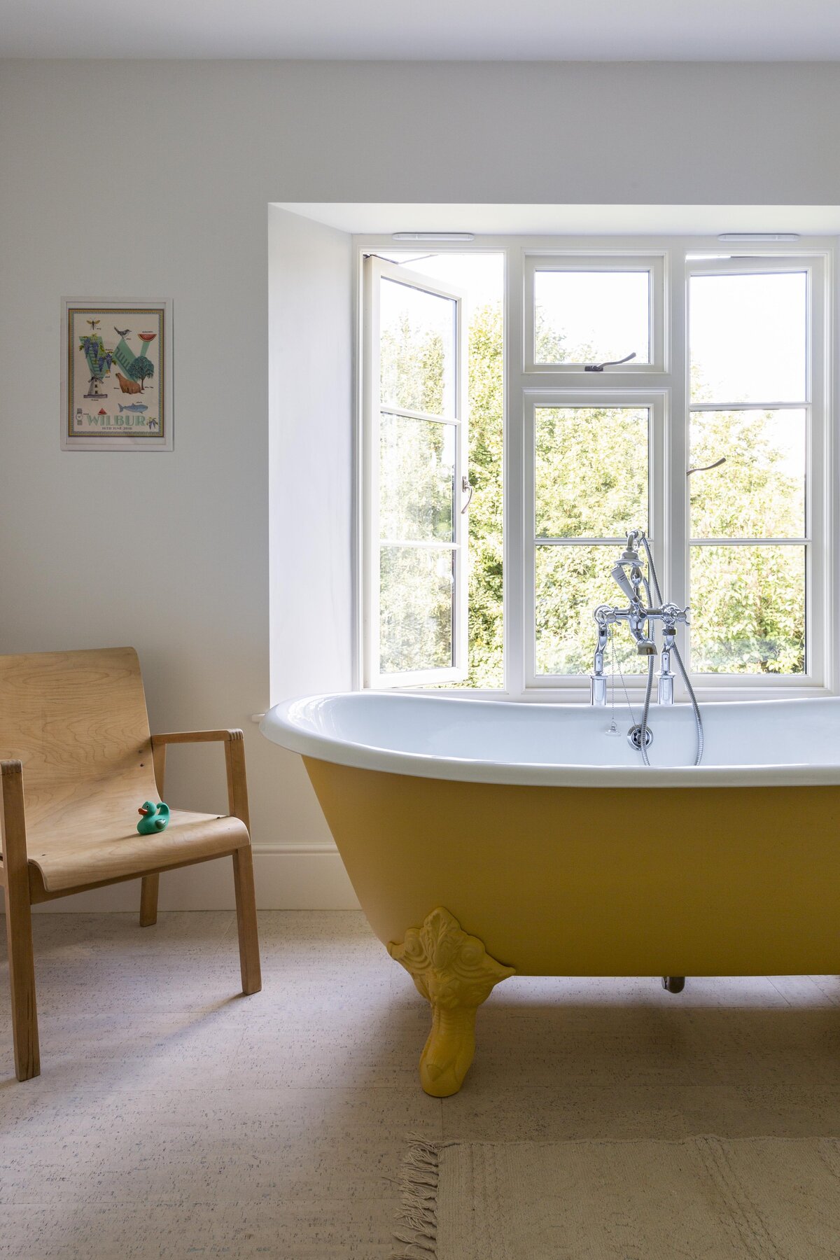 Yellow bath in the window with chair beside